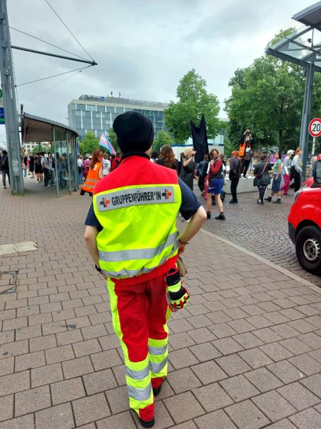 Gruppenführer*in des Sanitätskollektivs beobachtet eine laufende Demo und koordiniert den Einsatz.
