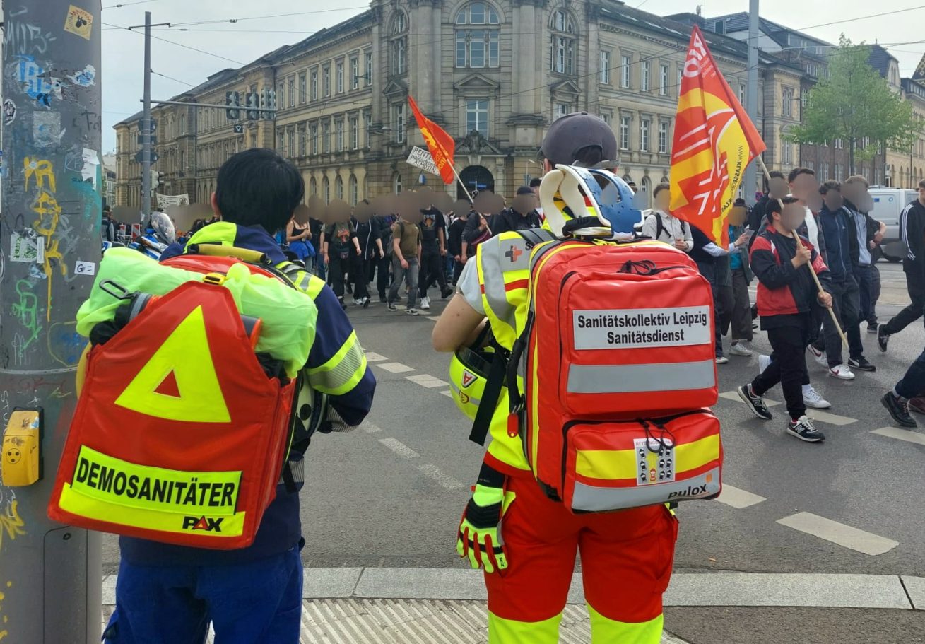Zwei Demosanitäter des SKL sichern eine Demonstration im Leipziger Stadtzentrum medizinisch ab. Es sind mehrere hundert Teilnehmer mit da.