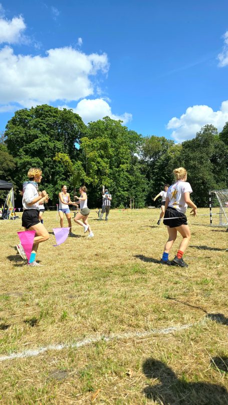 Personen spielen Discofoot auf einem Fußballfeld in einem Park.