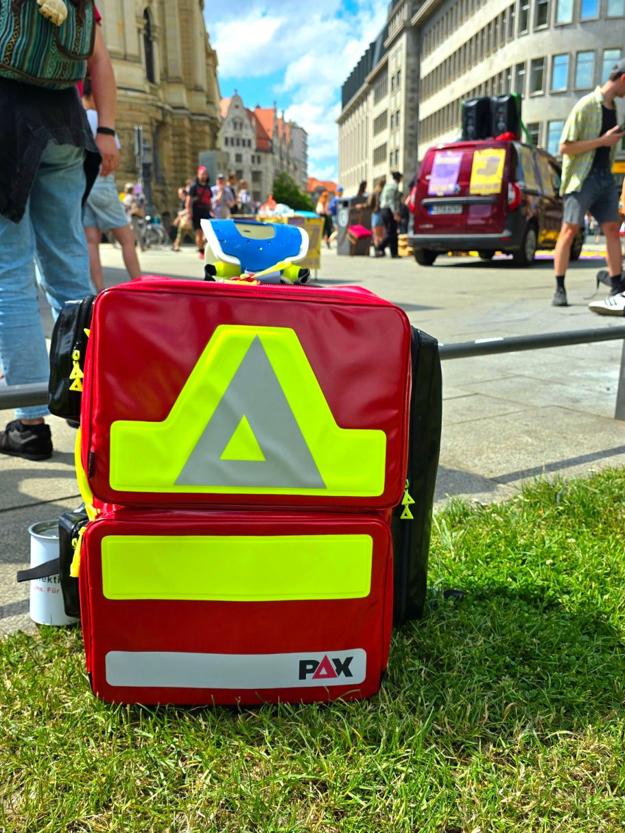 Ein Notfallrucksack des Sanitätskollektiv Leipzig, beladen mit viel lebensrettendem Material, steht bei einem Sanitätsdienst bereit.
