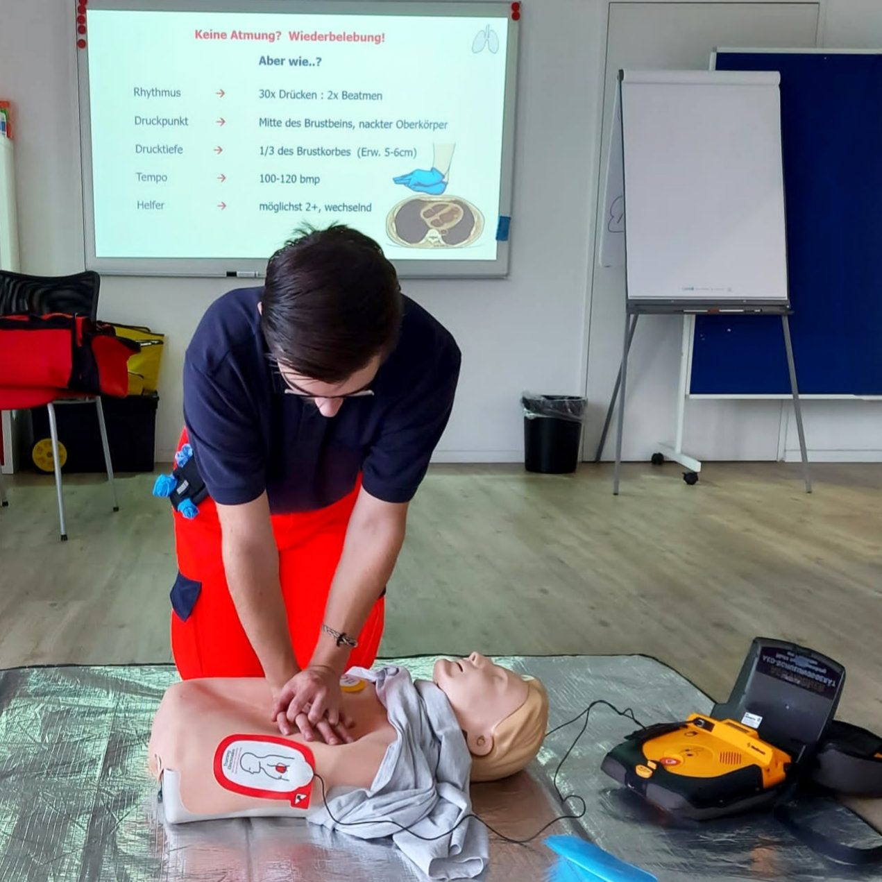 Ein Ausbilder des SKL zeigt während eines Notfalltrainings die Reanimation an einer Übungspuppe und erklärt wie dies geht.