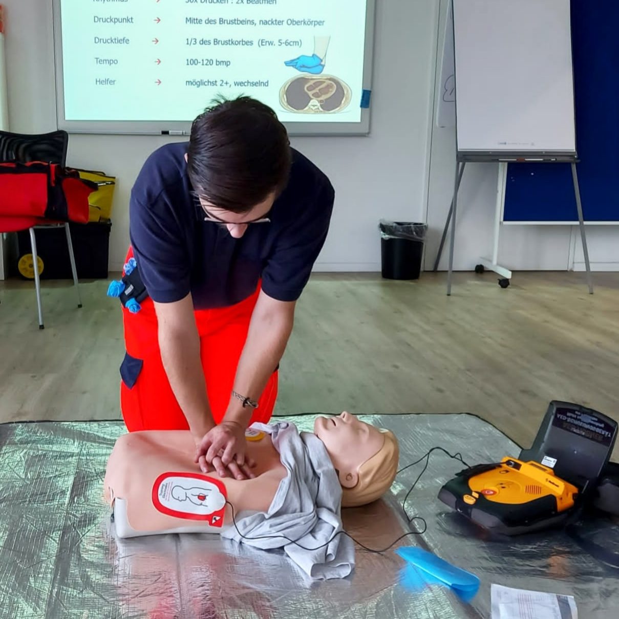 Ein Ausbilder des SKL zeigt während eines Notfalltrainings die Reanimation an einer Übungspuppe und erklärt wie dies geht.