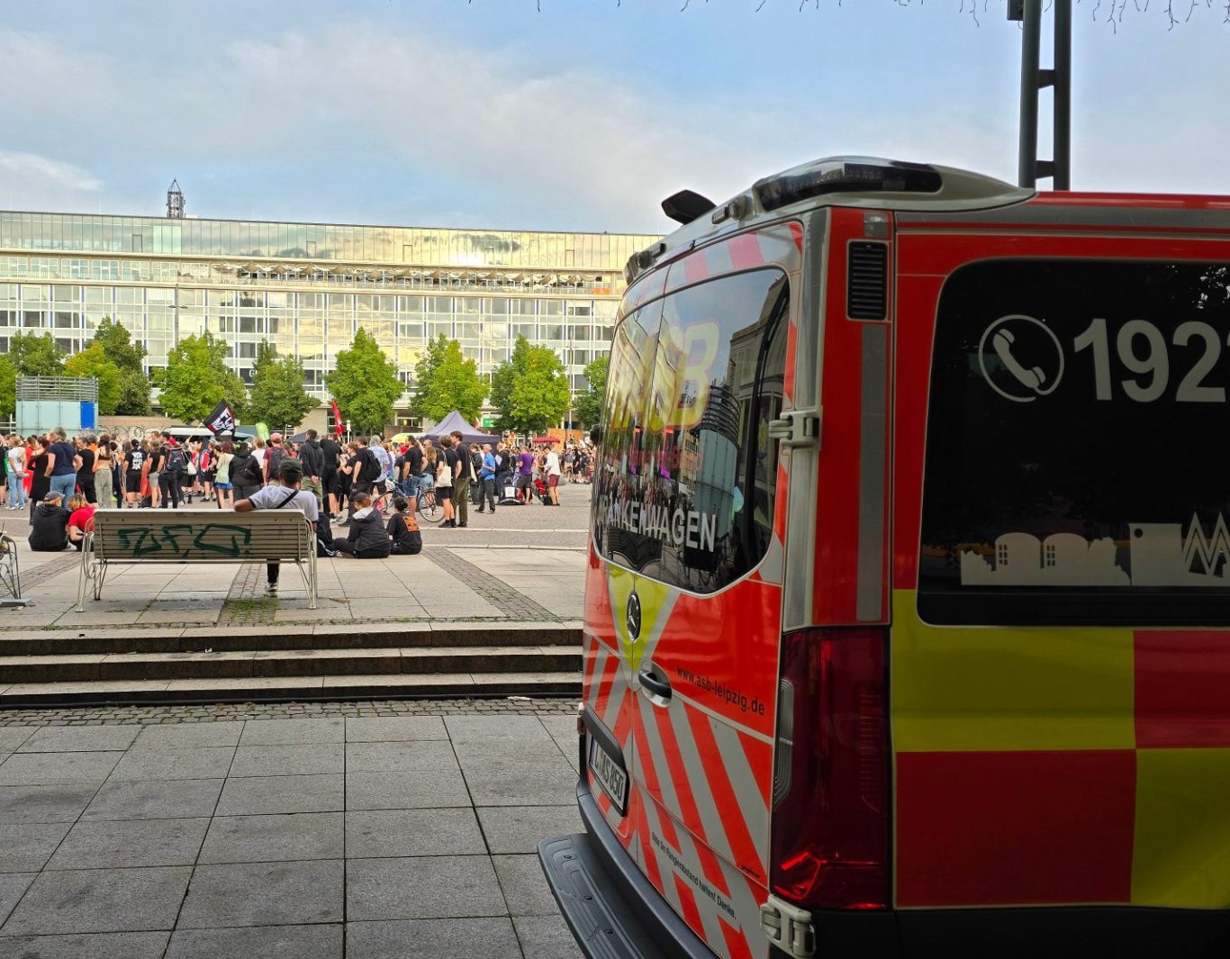 Auf dem Augustusplatz findet eine große Demonstration statt. Neben dieser steht ein Krankenwagen. ASB und SKL sichern gemeinsam ab.